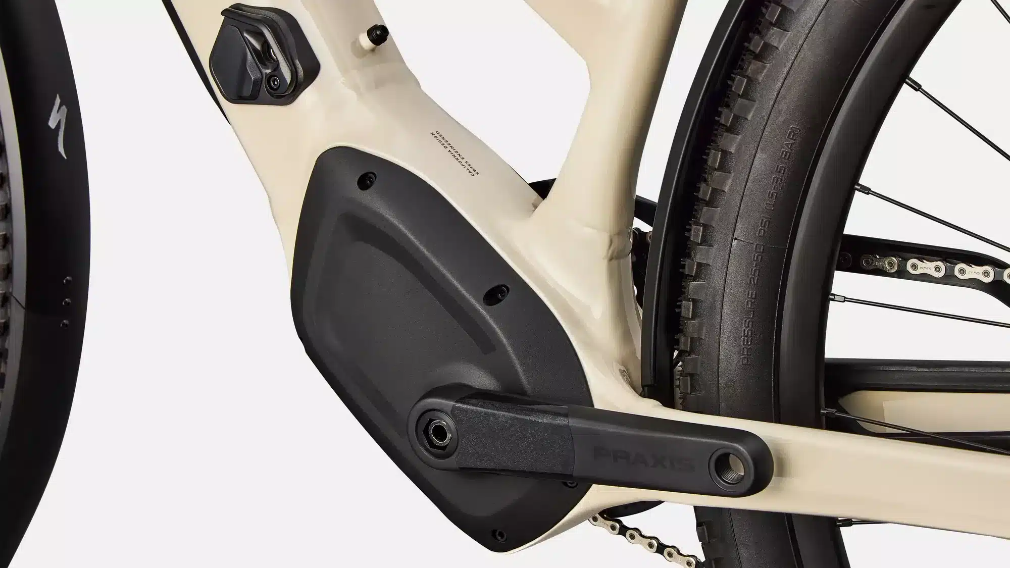 Detailaufnahme des hellbeigen Rahmens eines Specialized Turbo Tero 5.0 EQ Step-Through E-Bikes mit Fokus auf den Bereich um die Kurbel, die Kette und das Hinterrad. Man erkennt die