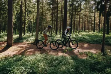Zwei Personen auf E-Bikes im Wald