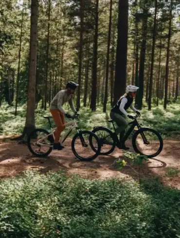 Zwei Personen auf E-Bikes im Wald