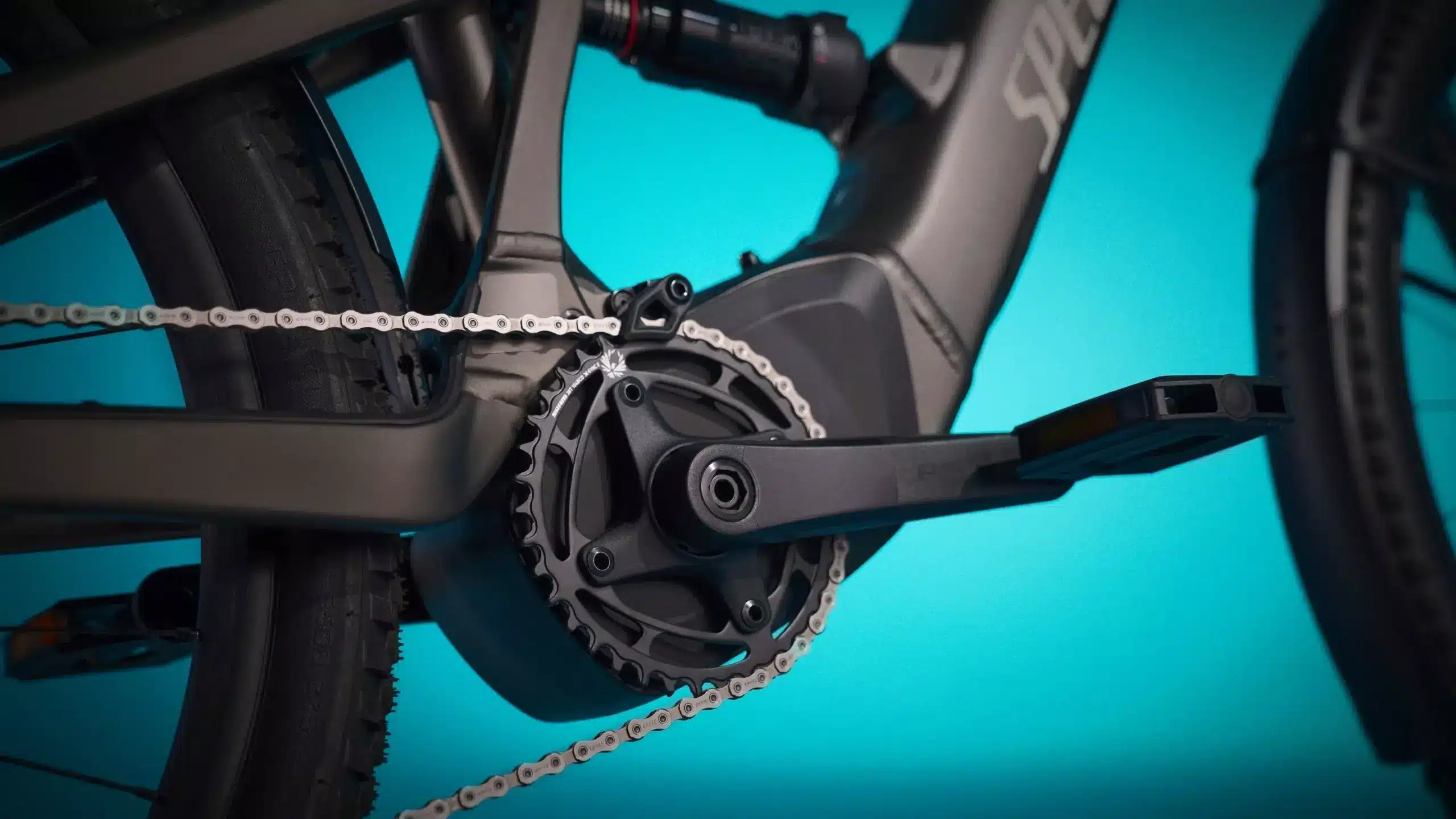 Nahaufnahme des Antriebsstrangs eines Specialized Turbo Tero X 4.0 E-Bikes, die das SRAM-Kettenblatt, die Kette und das Pedal zeigt.