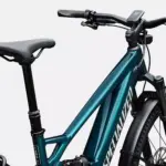 Vorderansicht eines tealfarbenen Specialized Turbo Tero X 5.0 E-Bikes mit Vollfederung, hydraulischen Scheibenbremsen, einem integrierten Display am Lenker, einer Federgabel und Schutzblechen.