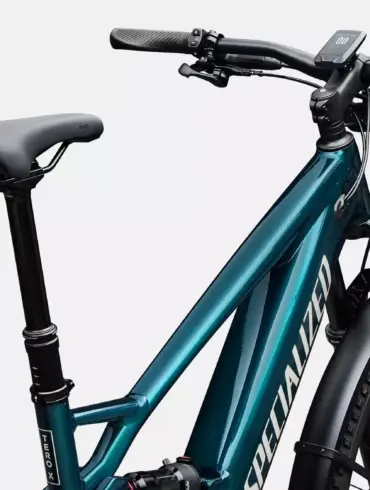Vorderansicht eines tealfarbenen Specialized Turbo Tero X 5.0 E-Bikes mit Vollfederung, hydraulischen Scheibenbremsen, einem integrierten Display am Lenker, einer Federgabel und Schutzblechen.