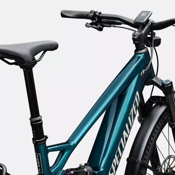 Vorderansicht eines tealfarbenen Specialized Turbo Tero X 5.0 E-Bikes mit Vollfederung, hydraulischen Scheibenbremsen, einem integrierten Display am Lenker, einer Federgabel und Schutzblechen.