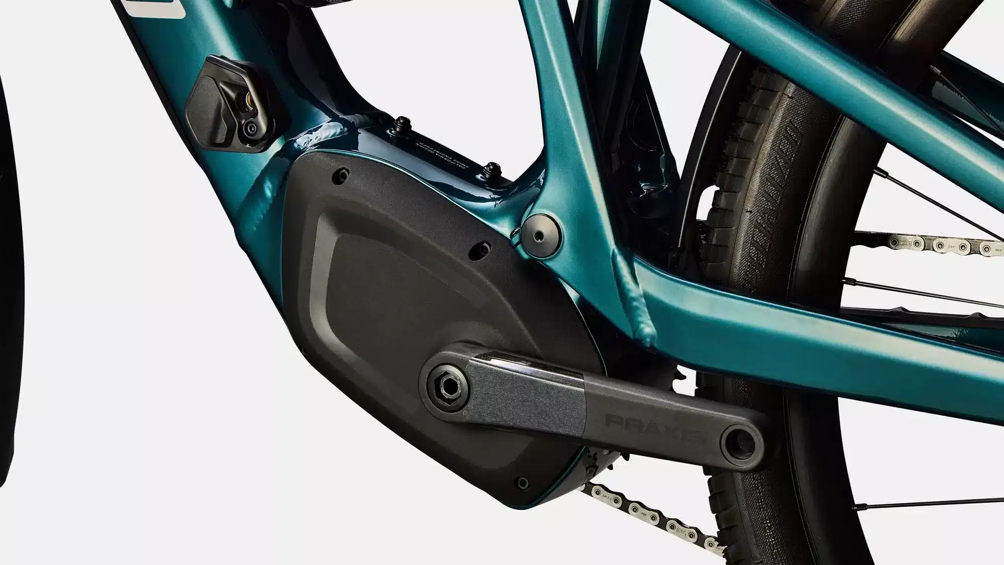 Detailansicht des Motors, des Kurbelarms mit der Aufschrift 'Praxis' und des Rahmens des Specialized Turbo Tero X 5.0 E-Bikes in smaragdgrün metallic