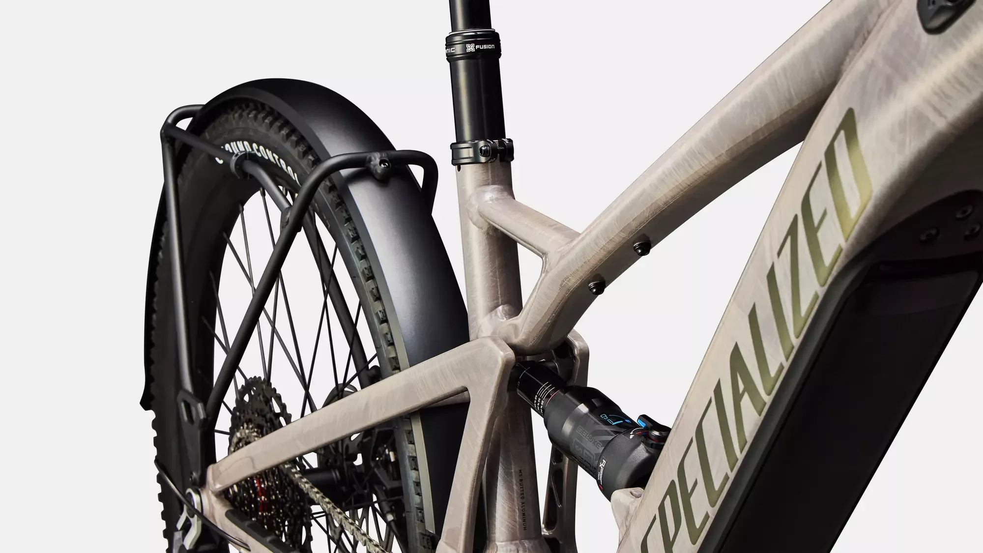 Nahaufnahme des Hinterrads und Rahmens eines Specialized Turbo Tero X 6.0 E-Bikes, mit Fokus auf Federungselement und Gepäckträger.