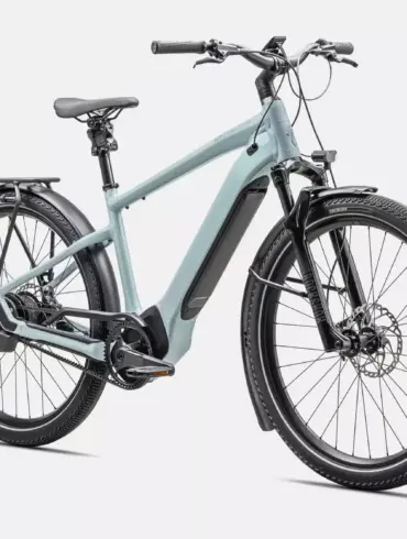 Ein hellblaues Specialized Turbo Vado 5.0 IGH E-Bike mit Schutzblechen, Gepäckträger, integriertem Akku und Federgabel.
