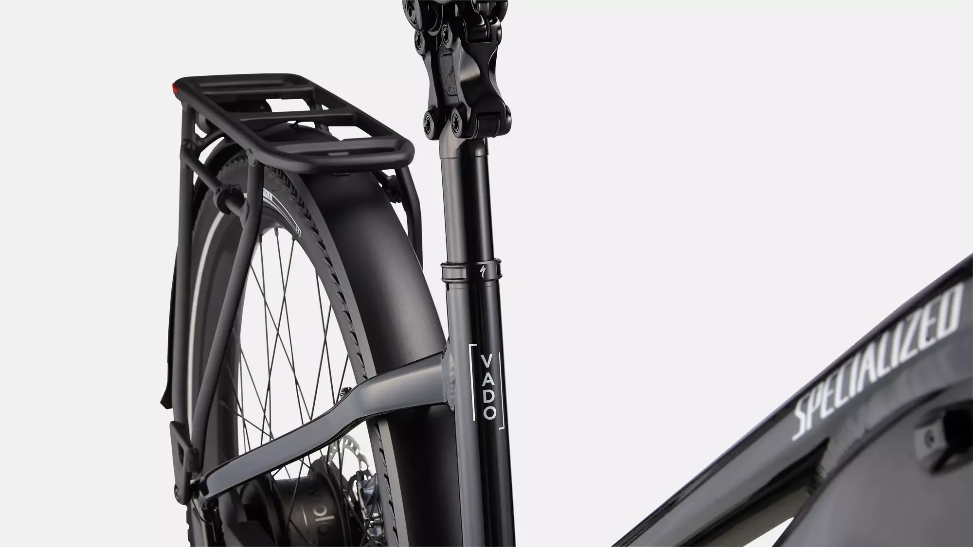 Detailaufnahme des schwarzen Specialized Turbo Vado 5.0 IGH E-Bikes mit Fokus auf den Gepäckträger, den hinteren Schutzblech und die Sattelstütze.