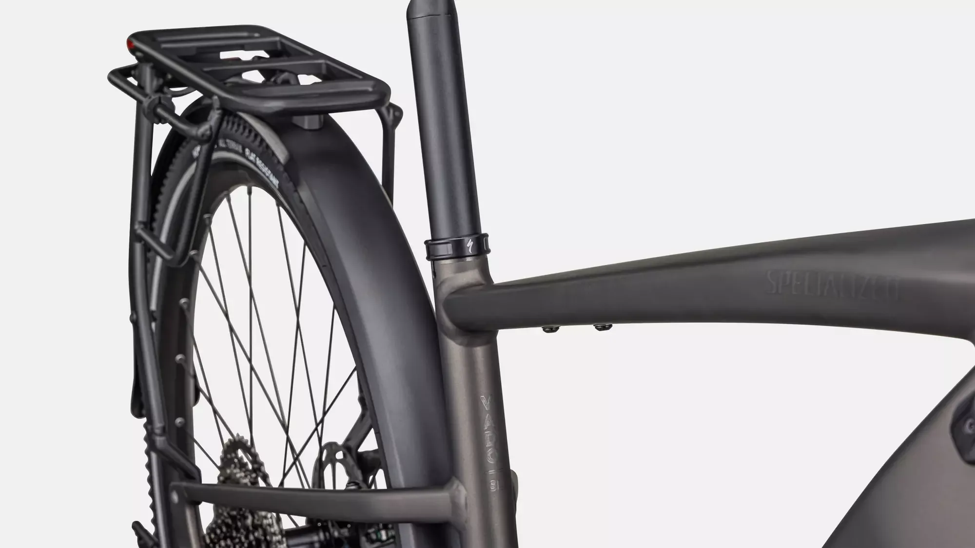 Nahaufnahme des Hinterrads eines Specialized Turbo Vado SL 2 4.0 EQ E-Bikes, mit integriertem Gepäckträger und Schutzblech.