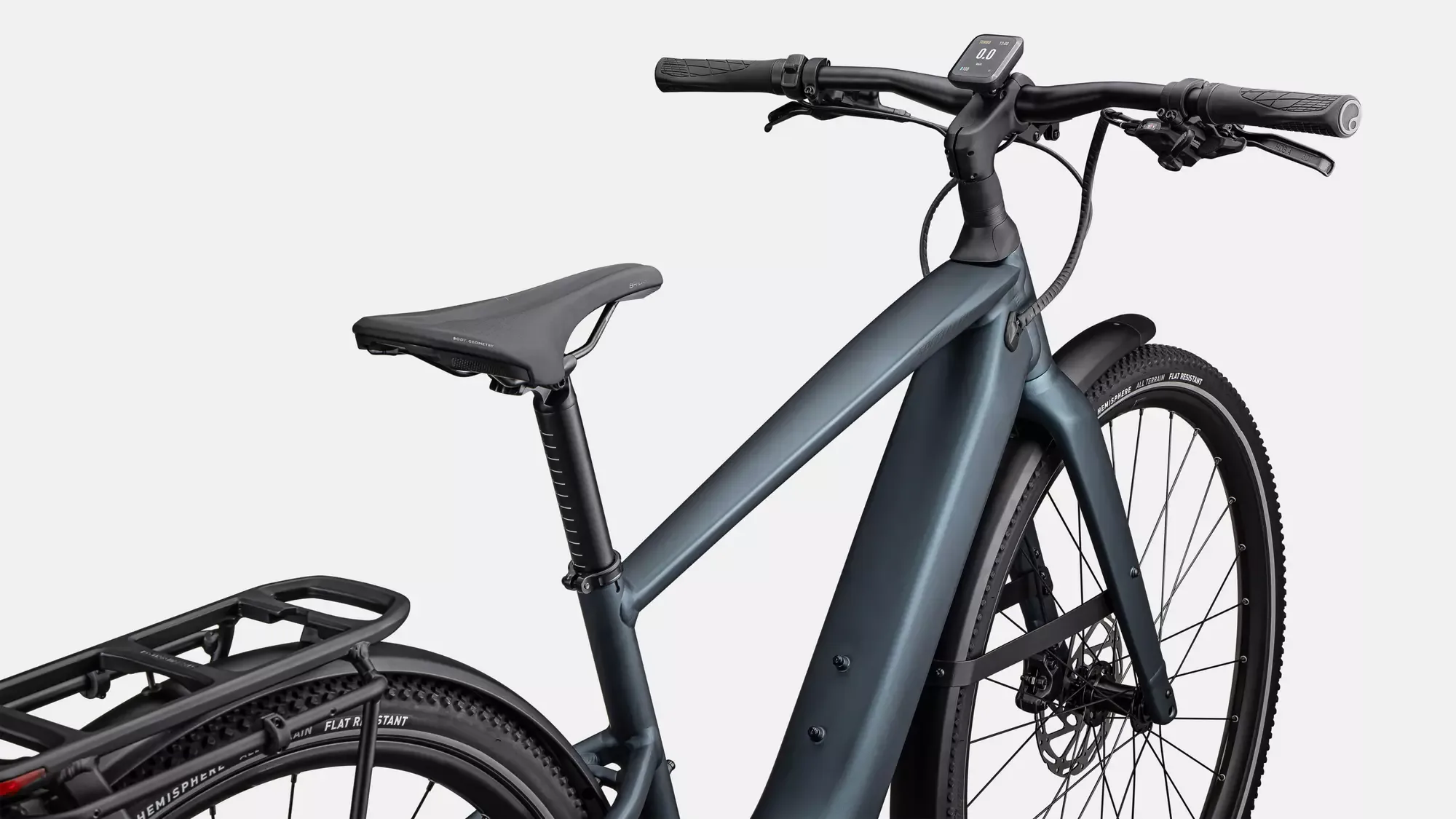 Detailaufnahme des Specialized Turbo Vado SL 2 5.0 EQ E-Bikes in Satin Deep Lake Metallic, mit Fokus auf Lenker, Sattel, Gepäckträger und Vorderreifen.