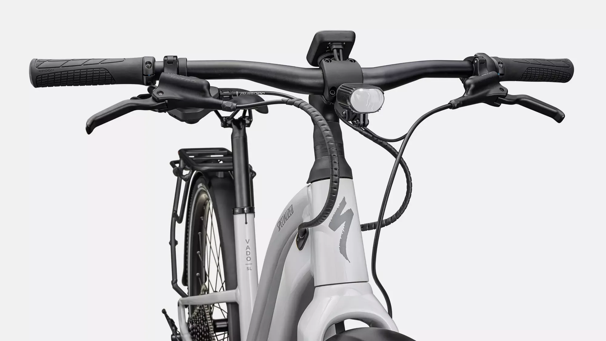 Detailaufnahme des Lenkers und Vorderteils eines weißen Specialized Turbo Vado SL 2 5.0 EQ Elektrofahrrads mit Blick auf Bedienelemente und Rahmen.