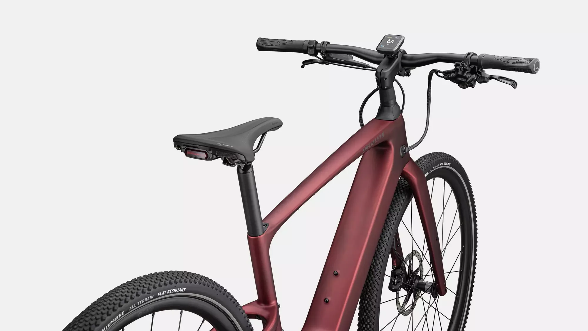 Seitenansicht eines dunkelroten Specialized Turbo Vado SL 2 6.0 Carbon E-Bikes mit Fokus auf den Rahmen, den Sattel und das Display.