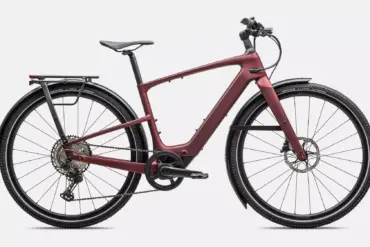 Rotes Specialized Turbo Vado SL 2 6.0 EQ Carbon E-Bike mit integriertem Akku, Seitenständer, Gepäckträger und Schutzblechen, isoliert auf weißem Hintergrund.
