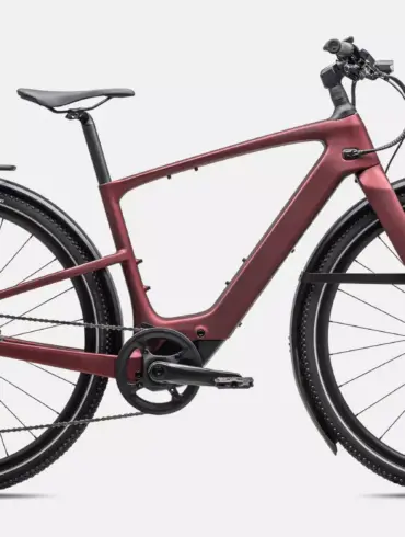 Rotes Specialized Turbo Vado SL 2 6.0 EQ Carbon E-Bike mit integriertem Akku, Seitenständer, Gepäckträger und Schutzblechen, isoliert auf weißem Hintergrund.