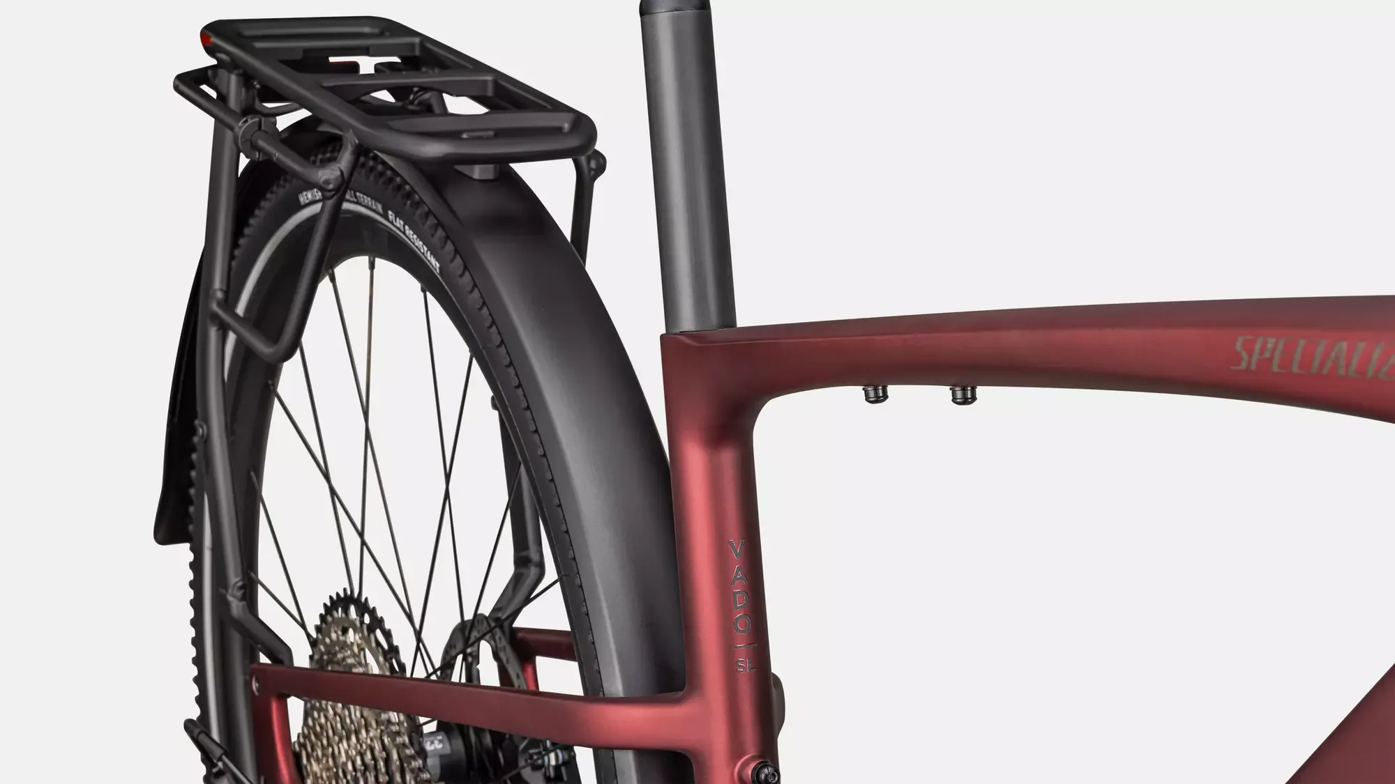 Detailaufnahme des roten Rahmens und Hecks eines Specialized Turbo Vado SL 2 6.0 EQ Carbon E-Bikes, mit Fokus auf den Carbonrahmen, Schutzblech und Gepäckträger.