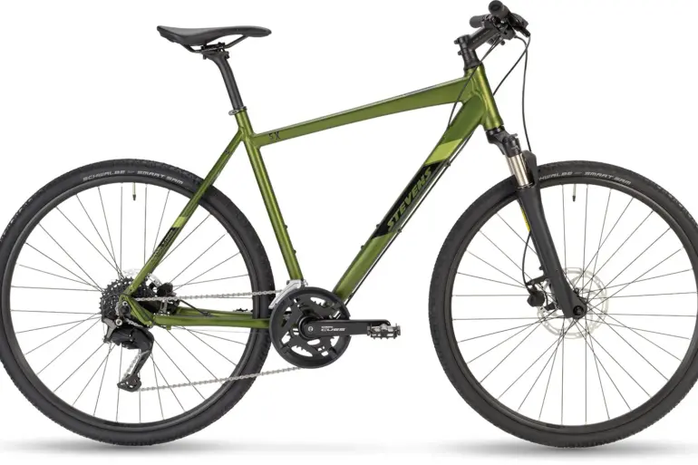 Ein Stevens 5X HT Fahrrad in der Farbe Metallic-Grün, von der Seite fotografiert, mit Fokus auf die Rahmengeometrie, die Federgabel und die Bereifung.