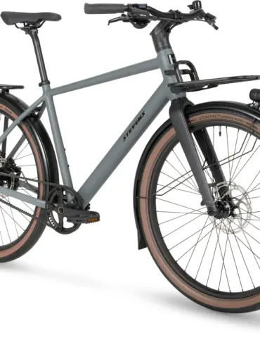 Stevens Amant 7.2 HT Fahrrad in der Farbe Basalt Grey, Vorderansicht mit Frontgepäckträger, Schutzblechen und braunen Reifen.