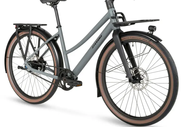 Stevens Amant 7.2 LT City-Bike in Basalt Grey, mit Fokus auf die Frontpartie mit Gepäckträger und Beleuchtung.