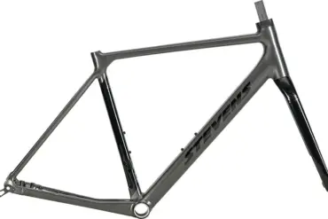 Ein grauer Rennrad-Rahmen mit schwarzem Stevens-Schriftzug und einer schwarzen Vollcarbon-Gabel, isoliert vor weißem Hintergrund.