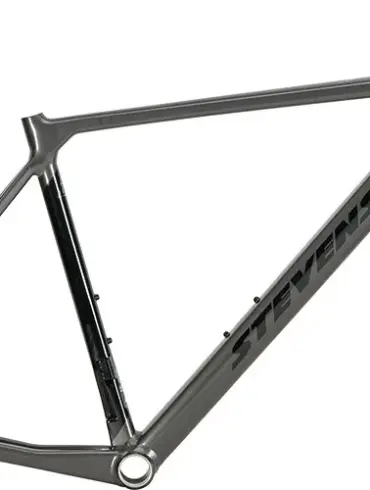 Ein grauer Rennrad-Rahmen mit schwarzem Stevens-Schriftzug und einer schwarzen Vollcarbon-Gabel, isoliert vor weißem Hintergrund.