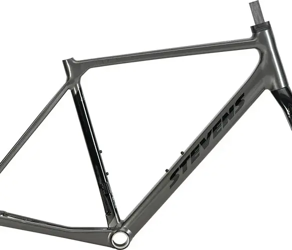Ein grauer Rennrad-Rahmen mit schwarzem Stevens-Schriftzug und einer schwarzen Vollcarbon-Gabel, isoliert vor weißem Hintergrund.