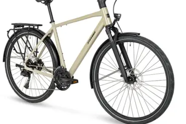 Seitenansicht eines Stevens Aviolo 7.1 HT Trekkingrads in Beige mit Gepäckträger und Schutzblechen.