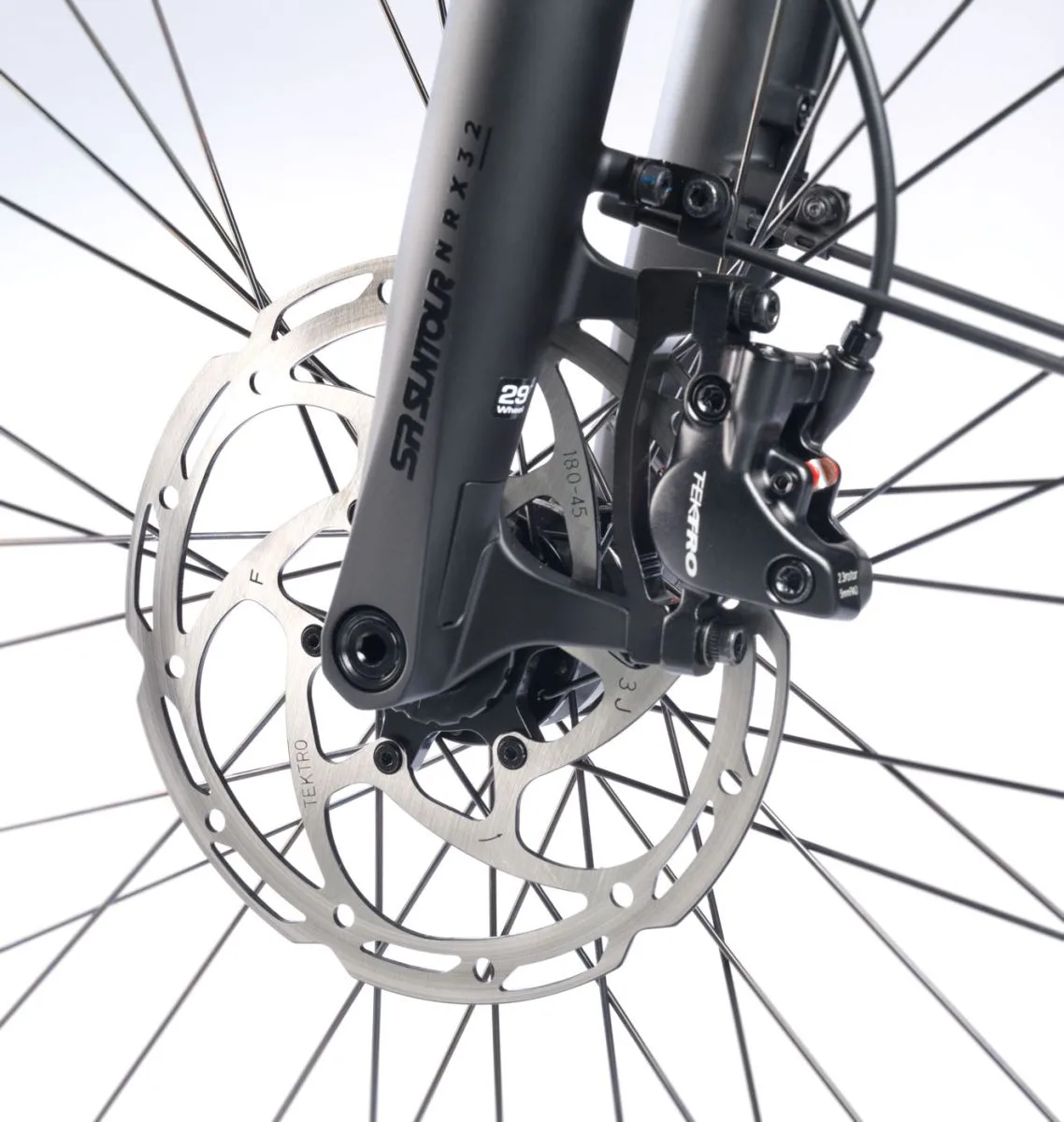 Detailaufnahme der Vorderradbremse mit Scheibenbremse, Bremssattel von Tektro und SR Suntour Federgabel eines STEVENS Aviolo 8.1 LT Trekkingrades.