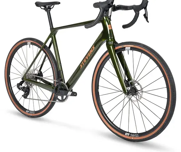 Grünes Stevens Camino RS Gravelbike mit braunen Reifen und DT Swiss Laufrädern, frontal von links gezeigt.
