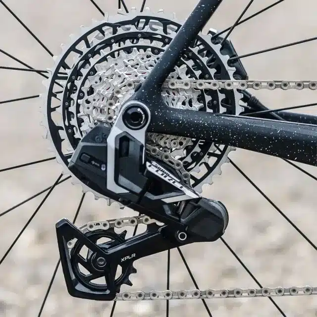 Detailansicht des SRAM Force XPLR E1 AXS Schaltwerks und der 13-fach Kassette am Hinterrad eines Stevens Camino RS Pro AXS Fahrrads.