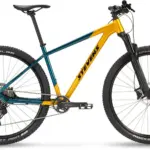 Seitenansicht eines Stevens Devil's Trail Mountainbikes in Gelb-Türkis mit schwarzen Reifen und Federgabel.