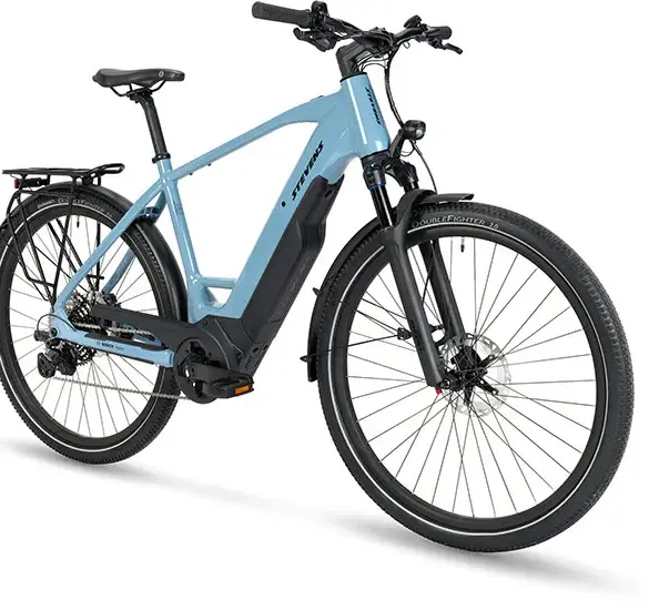 Frontansicht des STEVENS E-8X Tour Plus HT, einem hellblauen E-Tourenrad mit Racktime Gepäckträger und Bosch Performance Line CX Motor.