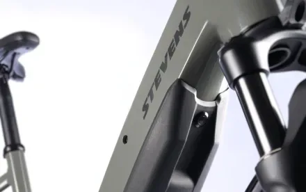Detailansicht des Rahmens eines grauen Stevens E-Bikes, mit Fokus auf den Schriftzug 'STEVENS' und die Vordergabel.