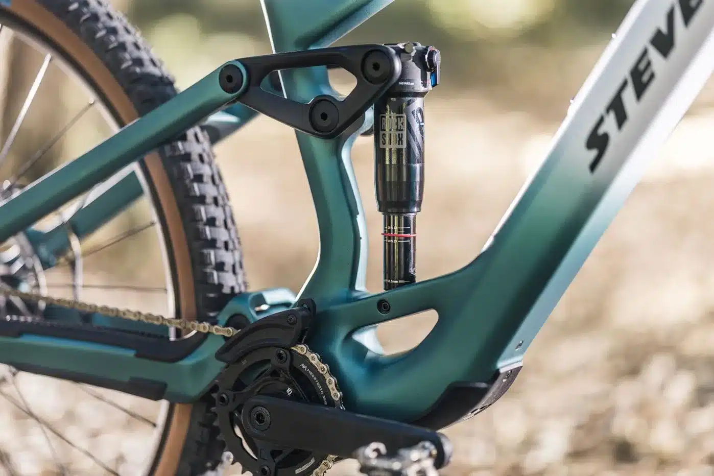 Detailaufnahme des Hinterbaus eines Stevens E-Maverick AM 7.4.3 Mountainbikes, Fokus auf den RockShox Dämpfer und das Schaltwerk.
