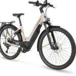 Seitenansicht eines beigefarbenen STEVENS E-Triton 7.8.1 Plus Forma Damen-E-Bikes mit tiefem Einstieg, Gepäckträger und Federgabel.