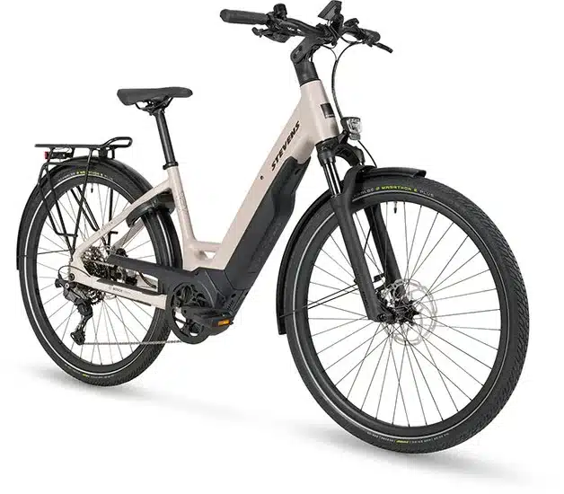 Seitenansicht eines beigefarbenen STEVENS E-Triton 7.8.1 Plus Forma Damen-E-Bikes mit tiefem Einstieg, Gepäckträger und Federgabel.