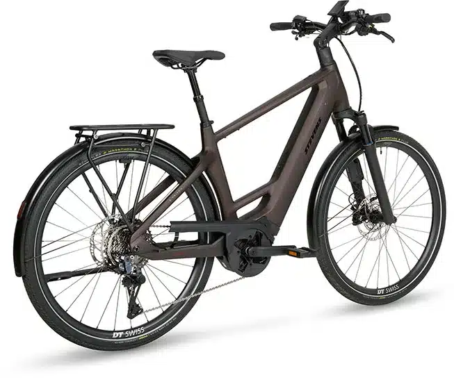 Seitenansicht eines braunen Stevens E-Triton 9.8.1 Plus HT E-Trekkingbikes mit Gepäckträger, Schutzblechen und Bosch-Display.
