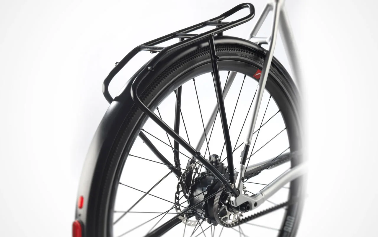 Nahaufnahme der Heckpartie eines Stevens E-Universe 9.8.1 Plus FEQ E-Bikes, fokussiert auf das Rad, den Gepäckträger, das Schutzblech und den Riemenantrieb.