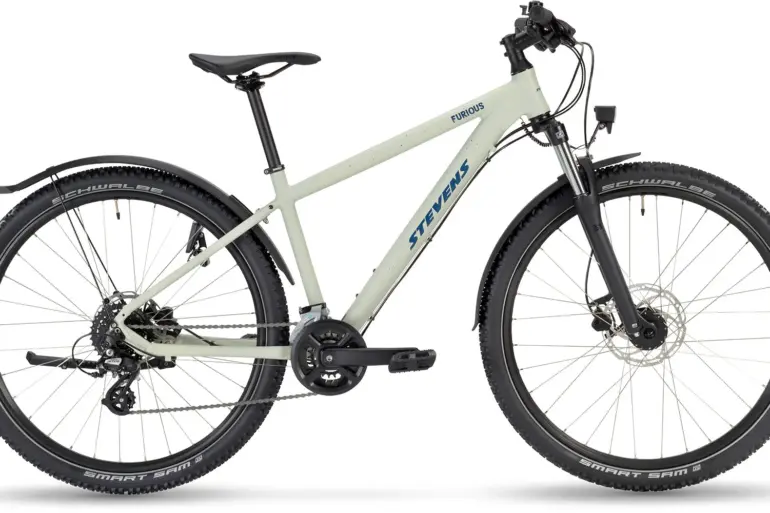 Seitenansicht eines Stevens Furious 27.5 Fahrrads in heller Farbgebung mit Schutzblechen, Lichtanlage und Federgabel.