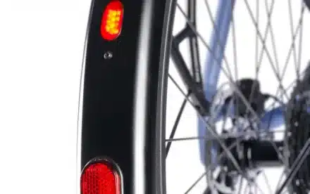 Nahaufnahme des Hinterradschutzes eines Stevens Kalea 6.1 HT Fahrrads, zeigt rote Rückleuchten und Speichen des Rades.