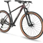Stevens Sonora ES Mountainbike in sportlicher Seitenansicht, zeigt die Gabel und das Vorderrad mit braunen Reifen sowie den Carbonrahmen.