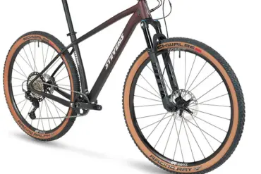 Stevens Sonora ES Mountainbike in sportlicher Seitenansicht, zeigt die Gabel und das Vorderrad mit braunen Reifen sowie den Carbonrahmen.