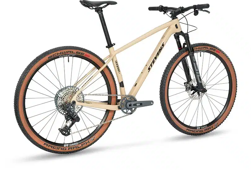 Seitenansicht eines sandfarbenen Stevens Sonora GX AXS Mountainbikes mit 29-Zoll-Laufrädern, RockShox Federgabel und braunen Reifen.