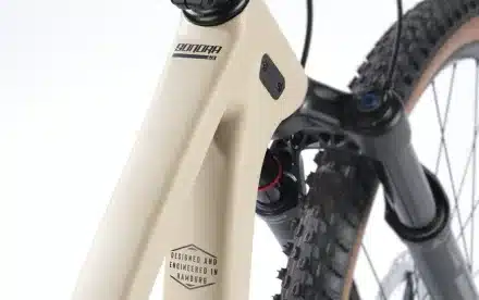 Detailaufnahme des vorderen Rahmens, der RockShox Gabel und des Reifens eines Stevens Sonora GX AXS Mountainbikes.