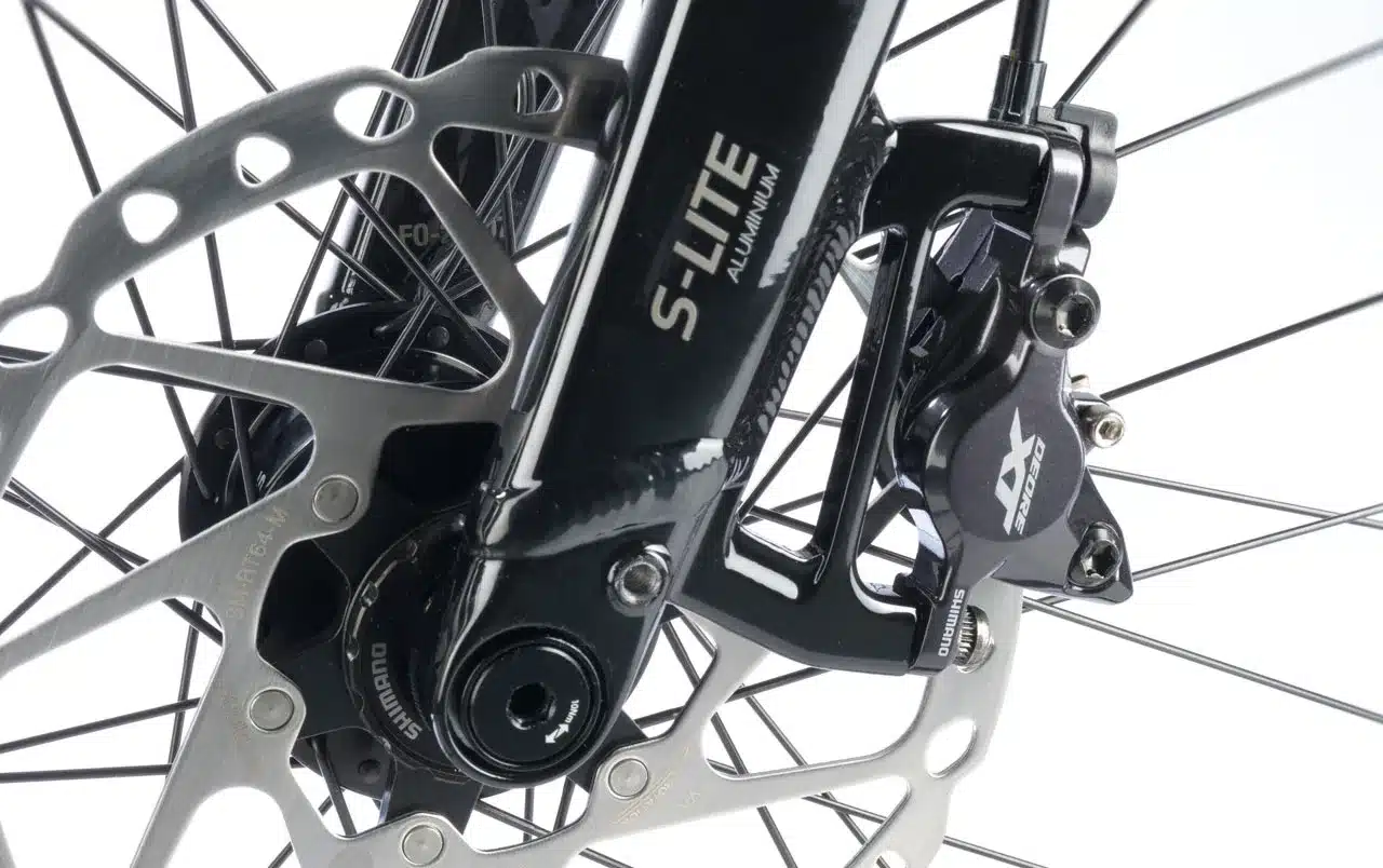 Nahaufnahme der vorderen Scheibenbremse mit Shimano Deore Bremssattel und S-Lite Aluminiumgabel eines Stevens Strada 800 Fahrrads.