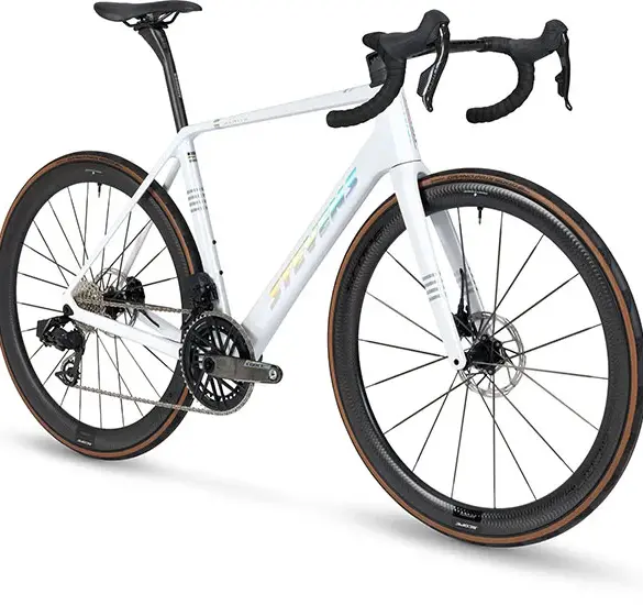 Stevens Xenith Endurance-Rennrad in weiß mit Carbonrahmen, dunklen Felgen und braunen Reifen.