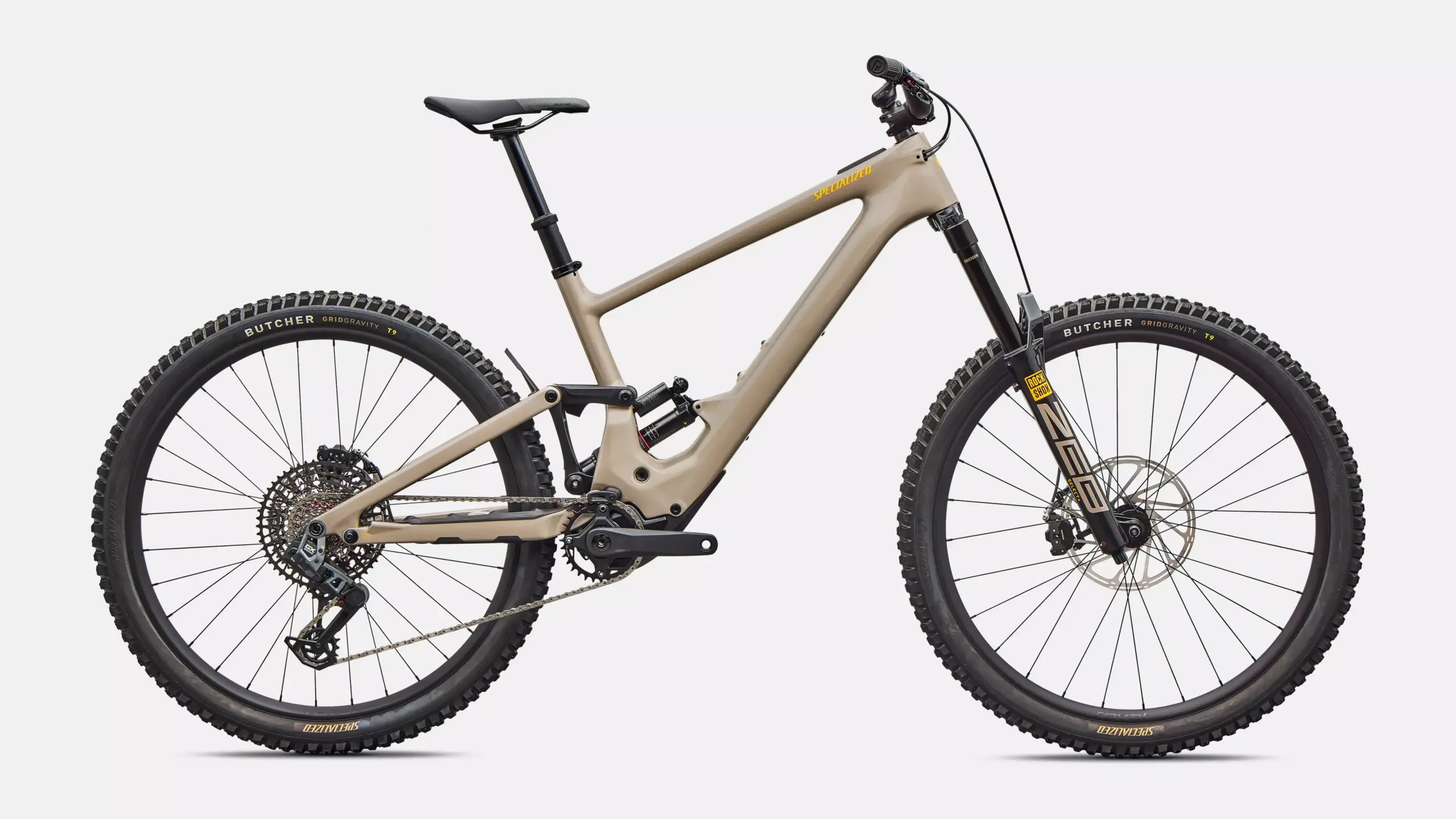 Specialized Turbo Kenevo SL 2 Expert E-Mountainbike, sandfarbener Rahmen, schwarze Federgabel und Dämpfer, schwarze Reifen mit Aufschriften wie 'Butcher' und 'Specialized'.