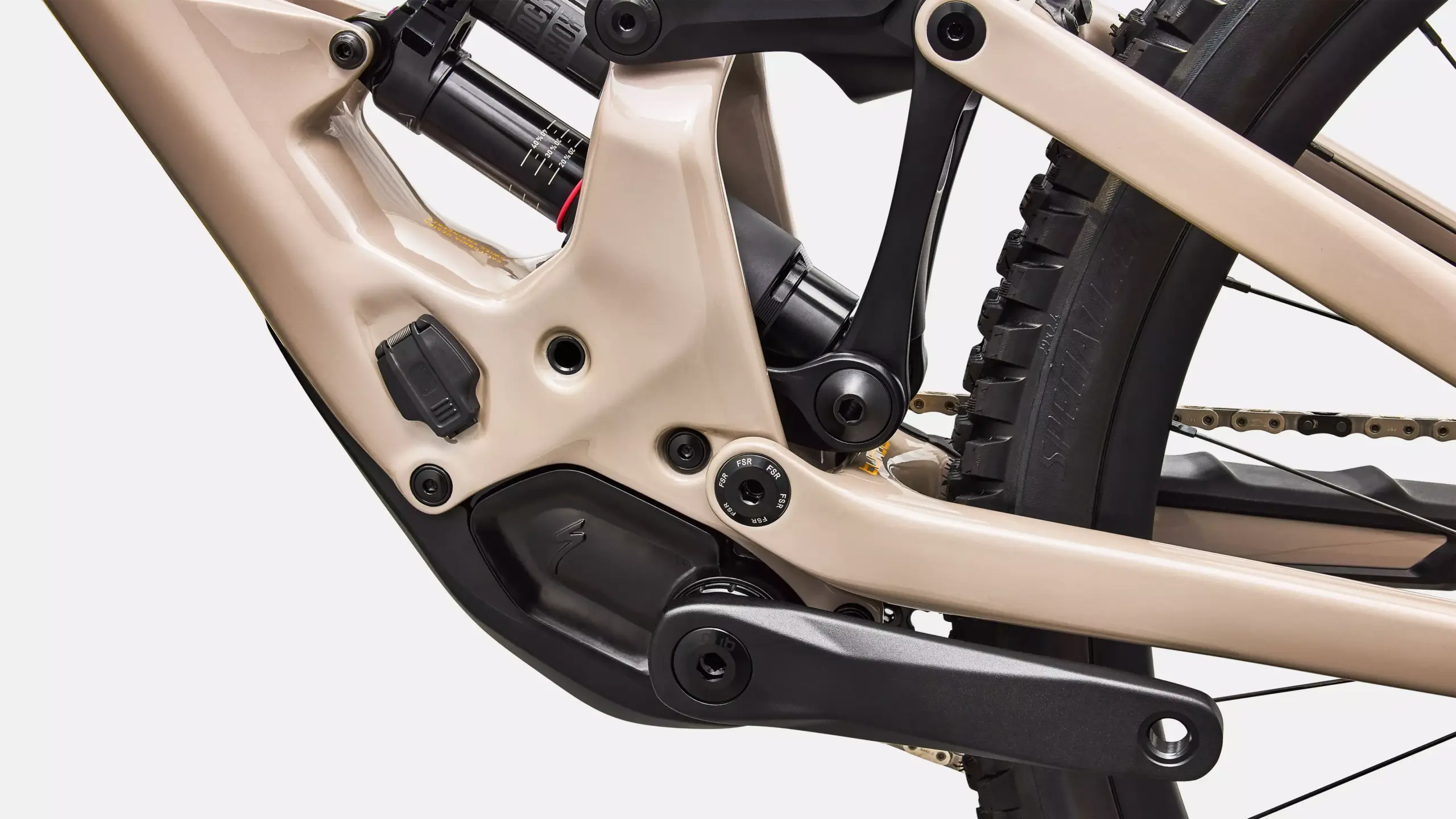 Detailaufnahme des Sandfarbenen Rahmens eines E-Mountainbikes mit RockShox Dämpfer, SRAM Kurbel und Kette.