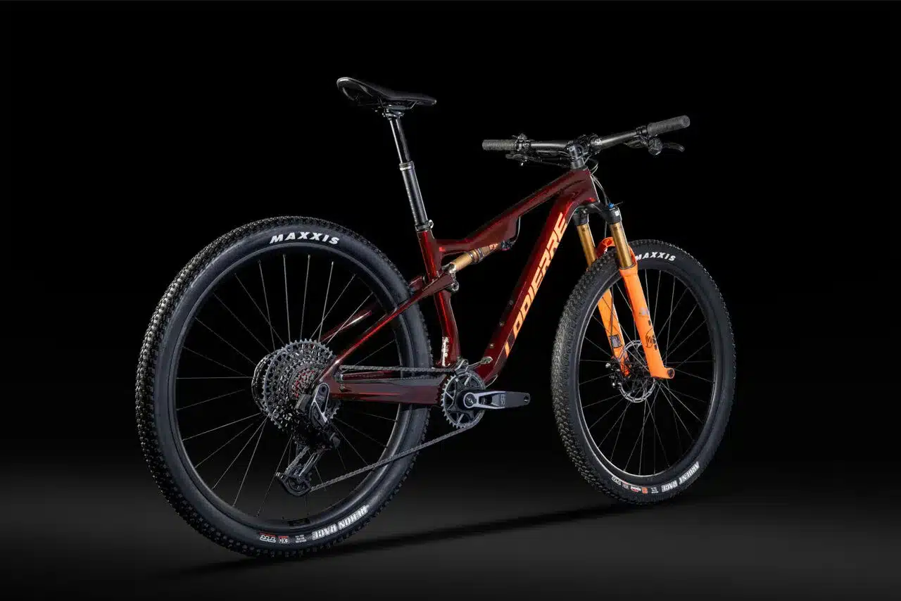 Ein rotes Lapierre XRM 10.9 Mountainbike mit orangefarbener Federgabel und schwarzen Maxxis Reifen, dargestellt vor schwarzem Hintergrund.