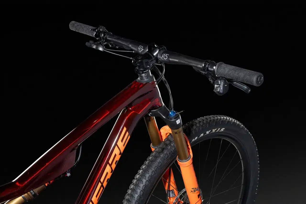 Nahaufnahme des Lenkers, Vorbaus, der Federgabel und des Vorderrads des XRM 10.9 Mountainbikes mit dunkelrotem Rahmen.
