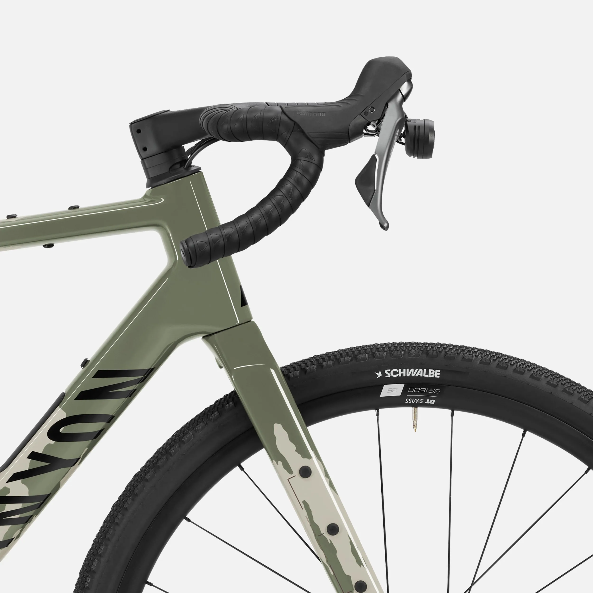 Nahaufnahme des Lenkers mit montiertem Licht und Schaltbremshebel eines Canyon Grizl CF 8 ESC Gravelbikes sowie des Vorderrads mit Schwalbe Reifen und DT Swiss Felge.