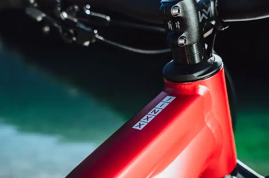 Nahaufnahme des oberen Rahmenteils eines roten MAXX Jinxx Mountainbikes mit silbernem Schriftzug.